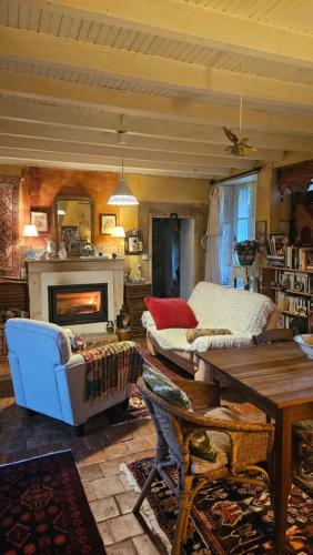 a living room with a couch and a fireplace at Longère Typique — Charmante chambre d'Hôte in Ids-Saint-Roch