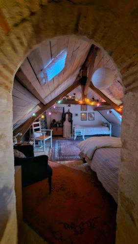 Schlafzimmer mit einem Dachgeschoss und einem großen Bett in der Unterkunft Longère Typique — Charmante chambre d'Hôte 