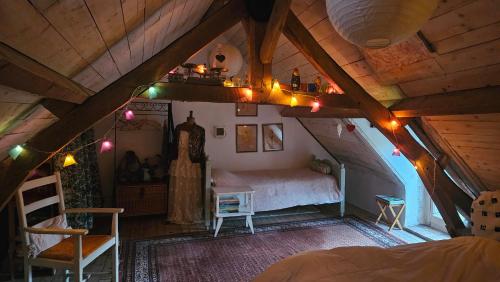 an attic bedroom with a bed and lights on the ceiling at Longère Typique — Charmante chambre d'Hôte in Ids-Saint-Roch