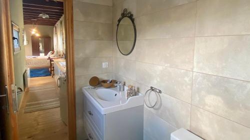 baño con lavabo y espejo en la pared en Little Garden cabin, en Perivolaki