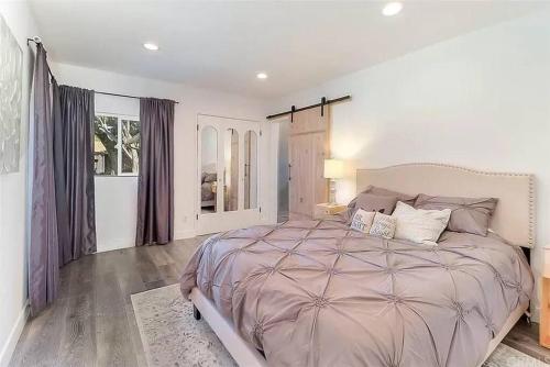 een slaapkamer met een groot bed en een raam bij ৎ୭ Canoga Park View ৎ୭ in Los Angeles