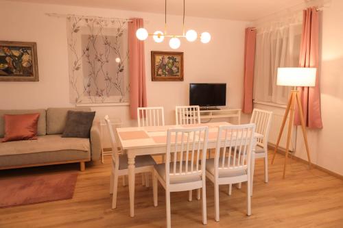 un soggiorno con tavolo, sedie e divano di Proton apartment a Jáchymov