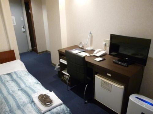a hotel room with a desk with a television and a bed at Hotel Wakow - Vacation STAY 22126v in Yonago