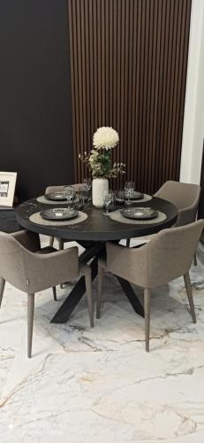 a black dining room table with chairs and a vase of flowers at Dream Loft in Puente Genil