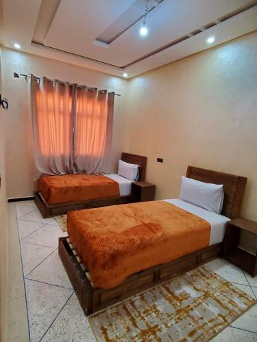 Residence Adnan luxury Appartments في ورززات: غرفة نوم بسريرين ونافذة