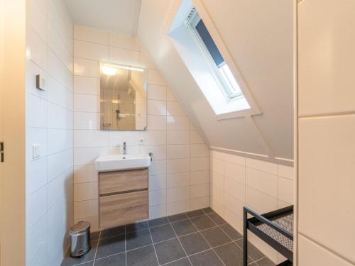 un baño con lavabo y espejo en Cozy Retreat with parking, en Scherpenisse