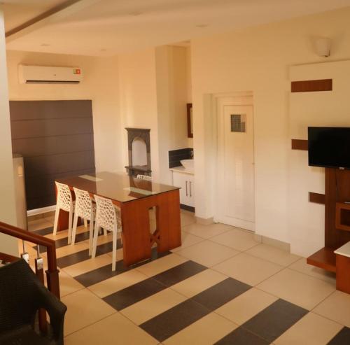 a kitchen with a table and chairs in a room at Royad Calicut Farm House - Premium Villa with Pool Inside a Farm in Kozhikode