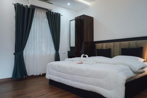 a bedroom with two white beds and a mirror at Royad Calicut Farm House - Premium Villa with Pool Inside a Farm in Kozhikode