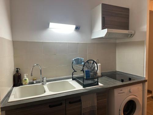 a kitchen with a sink and a washing machine at COCON 1 - Cathédrale & Castillet - Parking Gratuit in Perpignan
