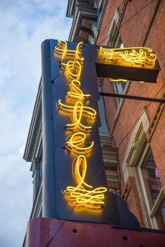a neon sign with yellow signs on the side of a building at Hostel Fish in Denver