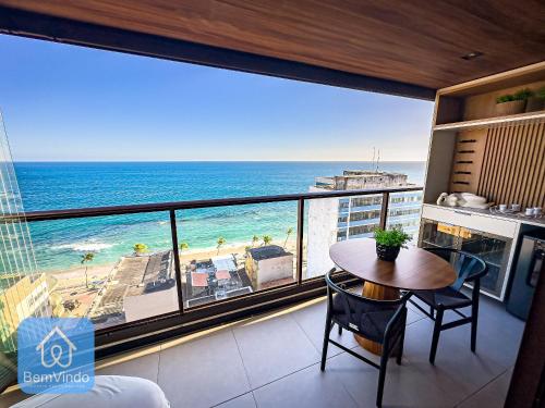 a room with a table and a view of the ocean at Apartamento de luxo na Barra com vista mar in Salvador