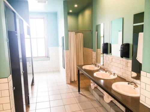a bathroom with two sinks and two mirrors at Hostel Fish in Denver
