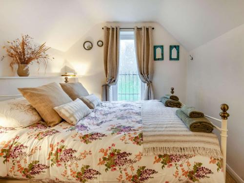 1 Schlafzimmer mit einem Bett mit Blumenbettdecke in der Unterkunft 2 Bed in Minchinhampton 72872 in Minchinhampton