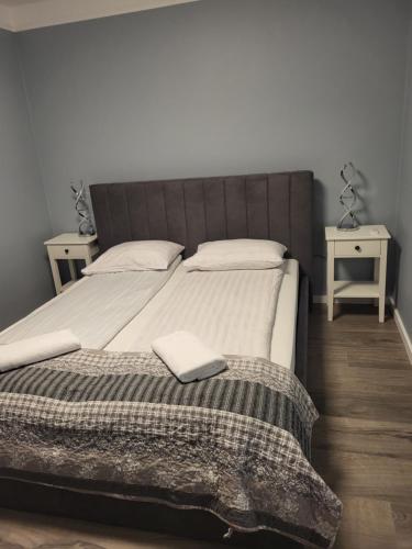 a bedroom with a large bed with two tables at Guesthouse Maximilian in Keflavík