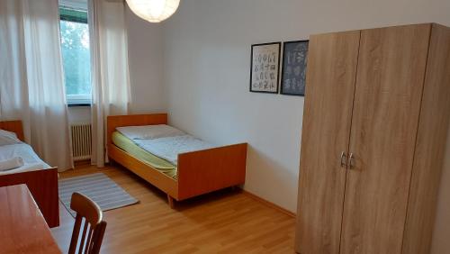 a small bedroom with a bed and a cabinet at Gasthaus Teveli in Kroatisch Geresdorf