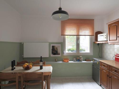 a kitchen with a table with a bottle of wine at Garden House Retreat in Drama