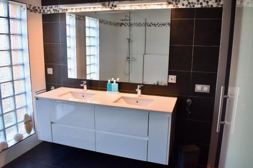 a bathroom with two sinks and a large mirror at La Casa Celestial in Platja d'Aro