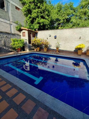 a swimming pool with blue tile in a backyard at Hostal La Pola in Santa Fe de Antioquia