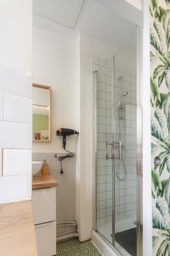 une salle de bain avec une douche avec une porte vitrée dans l'établissement LE REFUGE - NETFLIX I WIFI HAUT DEBIT I PARKING - Confort & Cosy, à Valenciennes