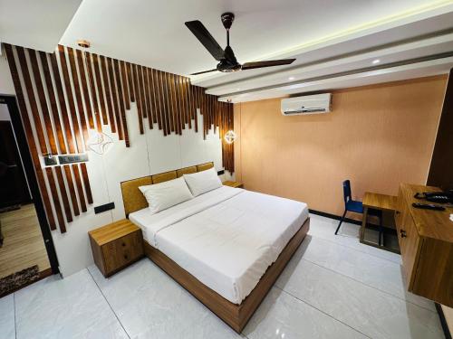 a bedroom with a bed and a desk in it at Farm Fort Resort By Luxdens Hotels in Kozhikode