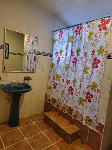 a bathroom with a shower curtain with a sink at Xungla Cancún in Cancún