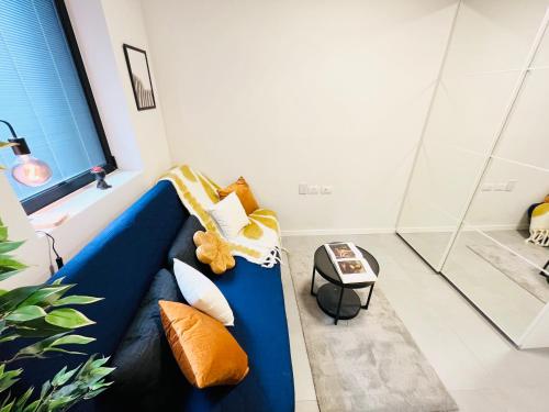 a blue couch with pillows in a room at Ayarkon CX - Elite Home Group in Tel Aviv