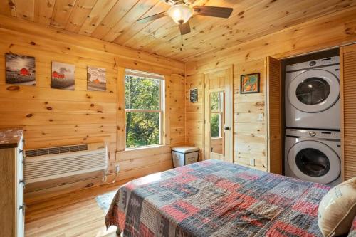 1 dormitorio con 1 cama en una cabaña de madera en Dream Weaver Cabin en Candler