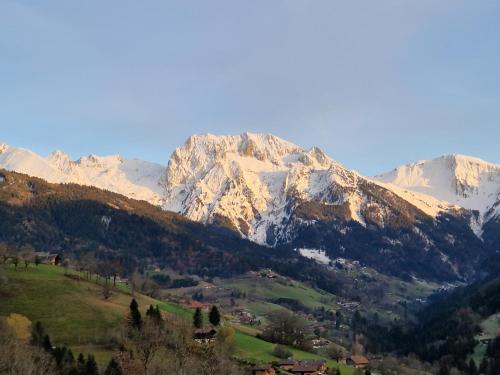 a snow covered mountain range with a town in a valley at Chalet de Manigod in Manigod