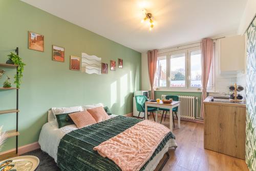 une chambre avec un lit et une table dedans dans l'établissement LE REFUGE - NETFLIX I WIFI HAUT DEBIT I PARKING - Confort & Cosy, à Valenciennes