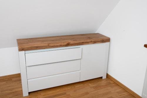 a white dresser with a wooden counter top at Domki Łowisko Wieniec in Gdów