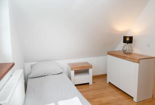 a small bedroom with a bed and a desk at Domki Łowisko Wieniec in Gdów