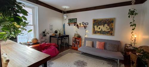 een woonkamer met een bank en een tafel bij Auberge de Jeunesse Magog-Orford Hostel in Magog-Orford