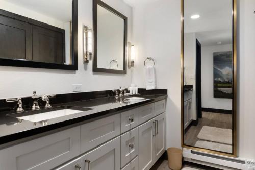 un bagno con due lavandini e un grande specchio di Lodge at 100 W Beaver Creek Blvd 605 ad Avon