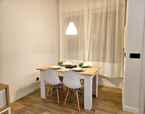 a white dining room table with two chairs and a light at Loft céntrico y acogedor UAT01526 in Pamplona