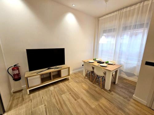 a living room with a television and a table with chairs at Loft céntrico y acogedor UAT01526 in Pamplona