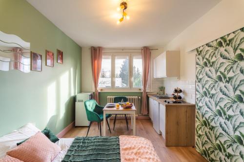 una pequeña cocina con mesa en una habitación en LE REFUGE - NETFLIX I WIFI HAUT DEBIT I PARKING - Confort & Cosy, en Valenciennes