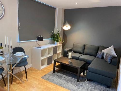 a living room with a couch and a table at City Centre Modern Studio Apartment - Westone FREE WIFI, GYM ACCESS, NETFLIX in Sheffield
