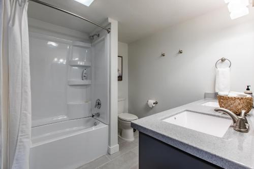 a white bathroom with a sink and a shower at Modern 2 Bed/1 Bath, In-Unit Laundry, Parking + 6 Blocks from Mayo in Rochester