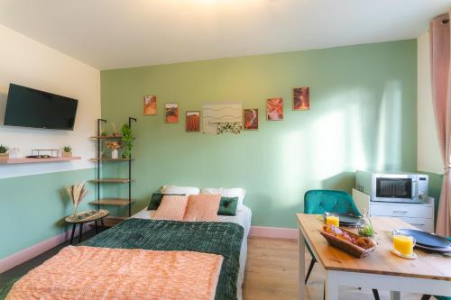 - un salon avec un lit et une table dans l'établissement LE REFUGE - NETFLIX I WIFI HAUT DEBIT I PARKING - Confort & Cosy, à Valenciennes