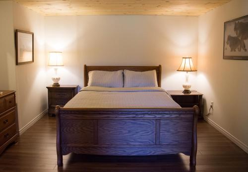una camera da letto con un letto con due lampade su entrambi i lati di The Nest in the Forest Bed and Breakfast (Hot tub and Sauna) a Lakefield