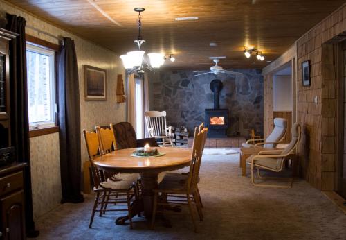 a dining room with a table and a fireplace at The Nest in the Forest Bed and Breakfast (Hot tub and Sauna) in Lakefield