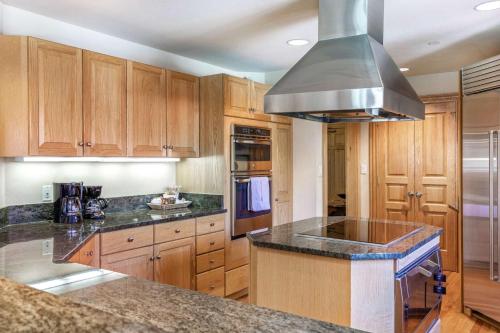 a kitchen with wooden cabinets and a stove top oven at Beaver Creek Lodge 411 in Beaver Creek