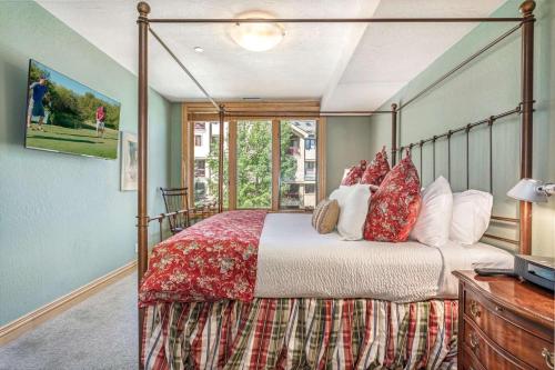 a bedroom with a canopy bed with red pillows at Beaver Creek Lodge 411 in Beaver Creek
