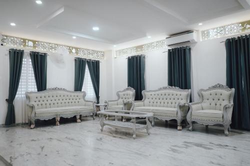 a living room with white couches and a coffee table at Royad Calicut Farm House - Premium Villa with Pool Inside a Farm in Kozhikode