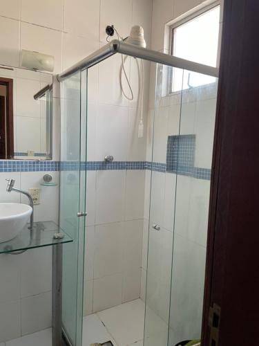 a bathroom with a glass shower and a sink at Shopping Campos Boulevard in Campos dos Goytacazes
