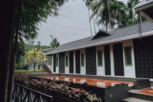 a house with black and white columns at Royad Calicut Farm House - Premium Villa with Pool Inside a Farm in Kozhikode