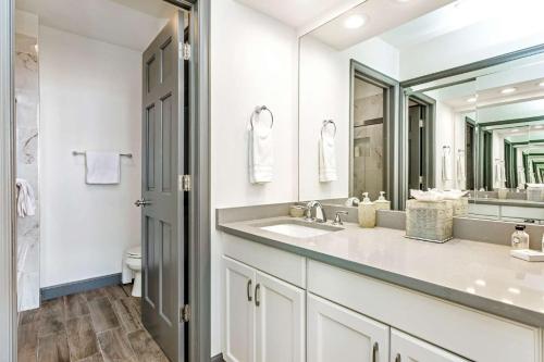 a white bathroom with a sink and a mirror at Highlands Lodge 302 in Beaver Creek