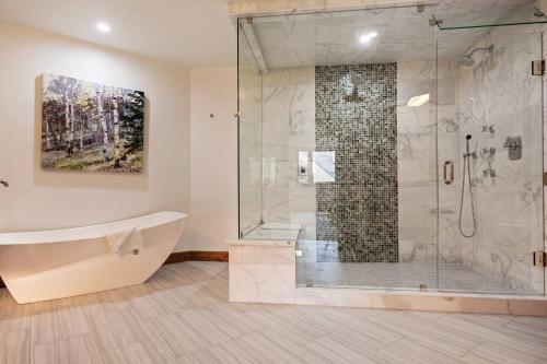 uma casa de banho com uma banheira e um chuveiro em vidro. em Beaver Creek Lodge 510 em Beaver Creek