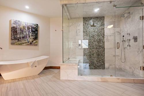 a bathroom with a tub and a glass shower at Beaver Creek Lodge 510 in Beaver Creek