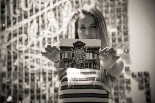 a woman holding up a picture of a house at Hostel Fish in Denver